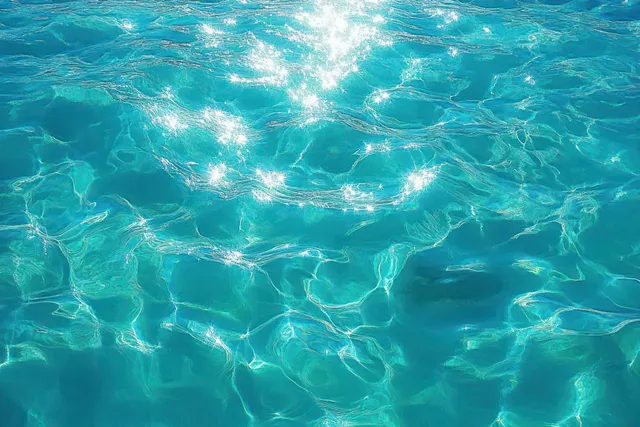 Overhead view of turquoise pool water with bright light caustics and rippling wave reflections.