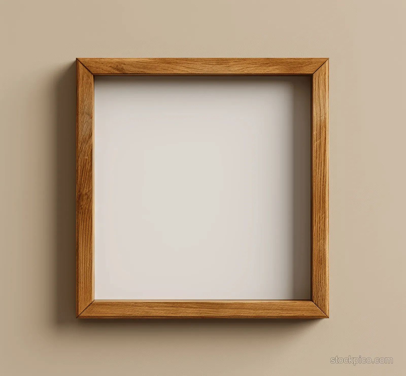 An empty wooden square picture frame hangs on a beige wall with a soft shadow.