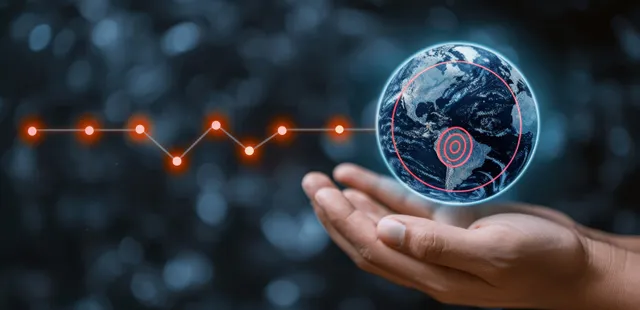 A hand holds a glowing blue holographic Earth with floating network nodes on a dark background.