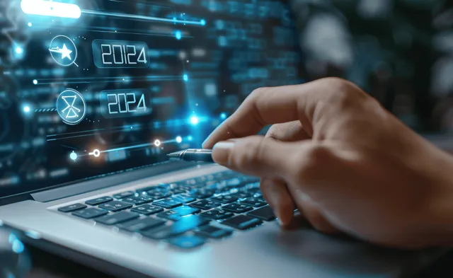 A hand presses a glowing progress bar showing 2023 transitioning to 2024 on a futuristic blue tech screen.