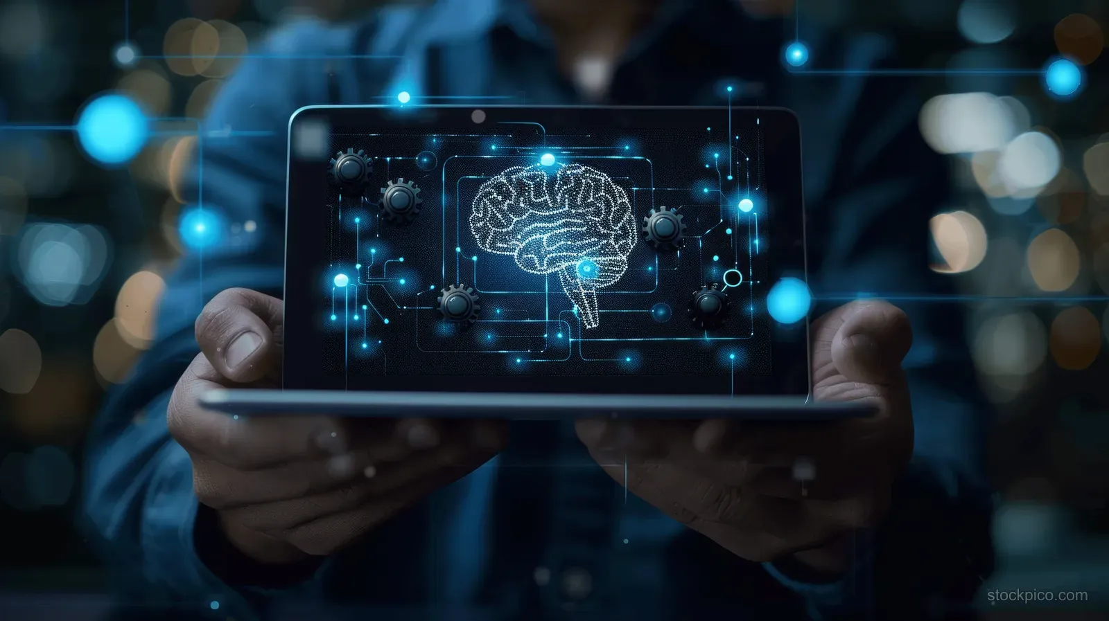 A businessman holds a tablet displaying a glowing AI brain graphic and chatbot interface icons in a dark office.