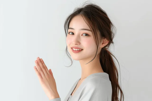 Smiling Japanese businesswoman presenting with hand gesture on white background