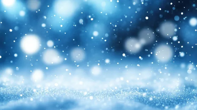 Soft glowing white particles drift over a blurred blue background, forming a serene winter bokeh glow.