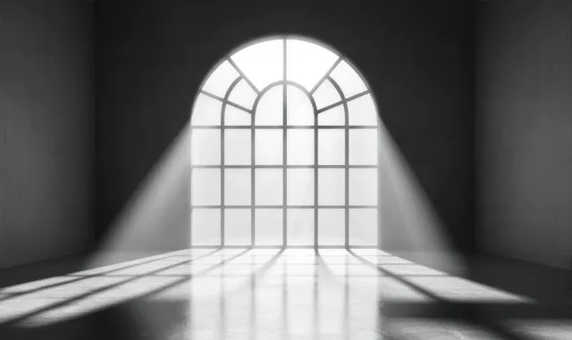 Sunlight streams through a tall arched window, casting grid shadow patterns across a polished floor