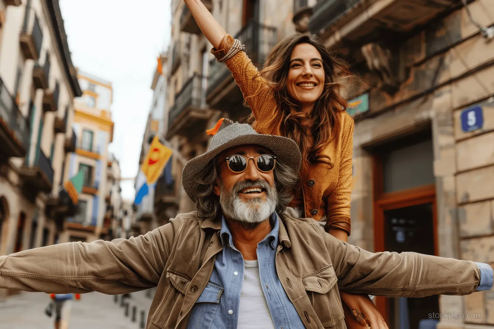 A smiling mature couple on a piggyback ride in a narrow Barcelona street.