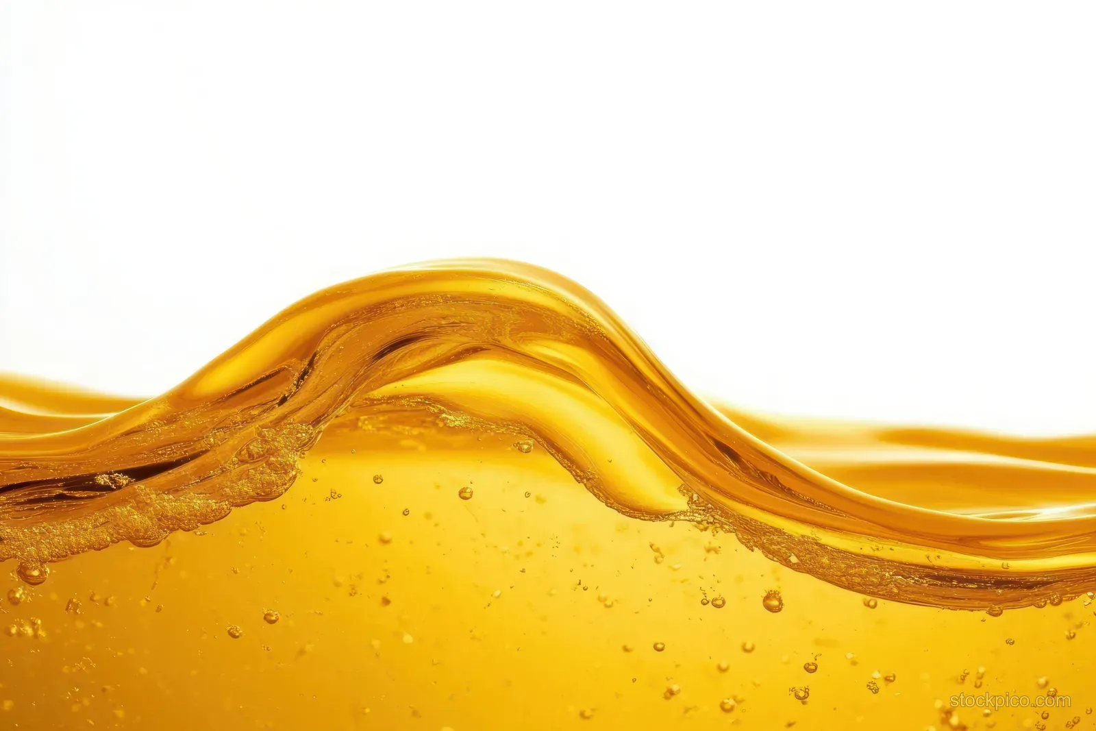 Golden liquid wave with suspended bubbles and glossy highlights cresting against a white background.