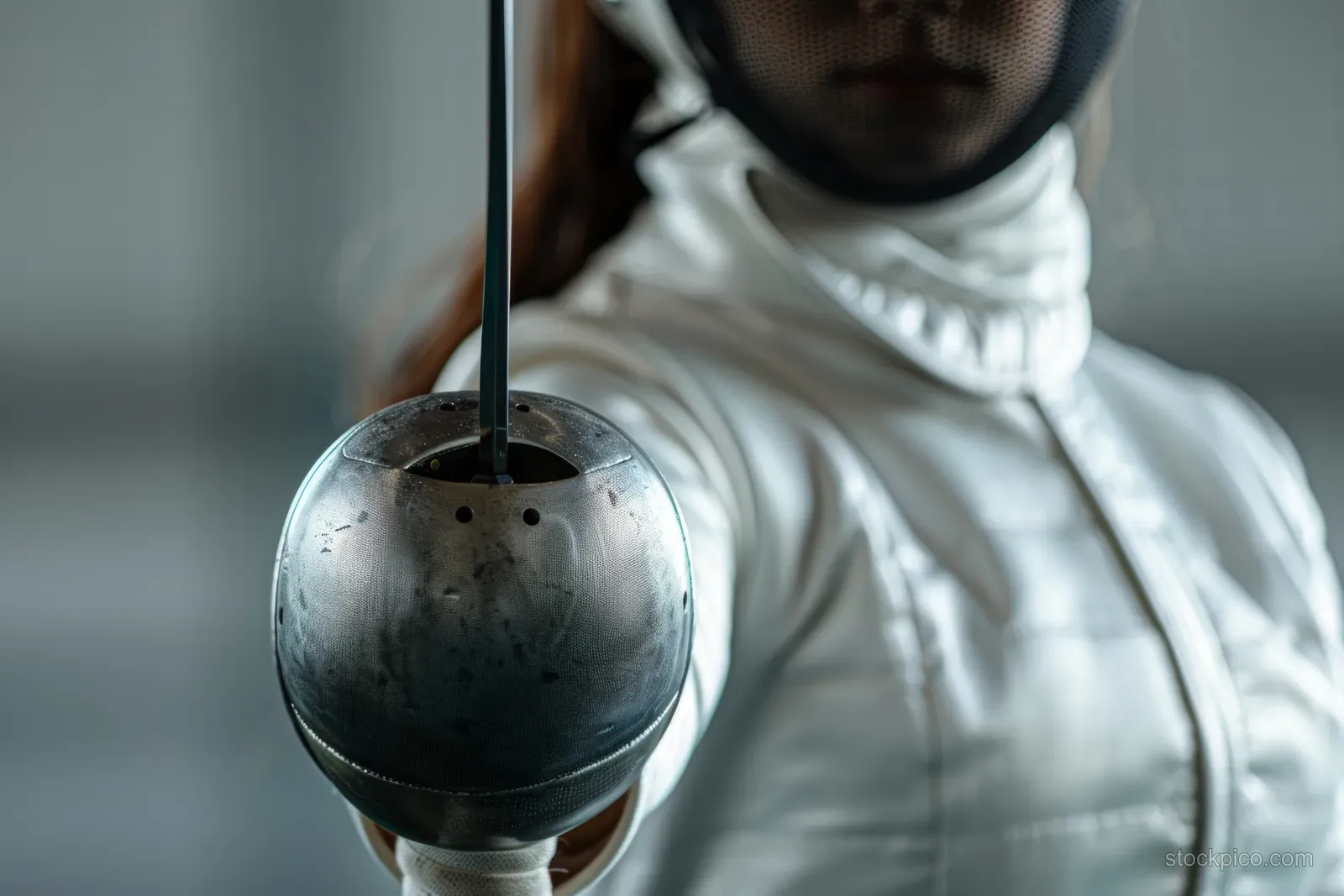 A South Korean female fencer lunges in fencing gear while the blade swings in front of the masked face.