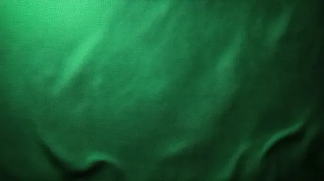 Close-up green fabric texture with gentle folds and soft light creating smooth highlights