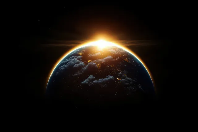 Sunrise lights up Earth’s illuminated continents and cloud bands with a glowing atmosphere against dark space.
