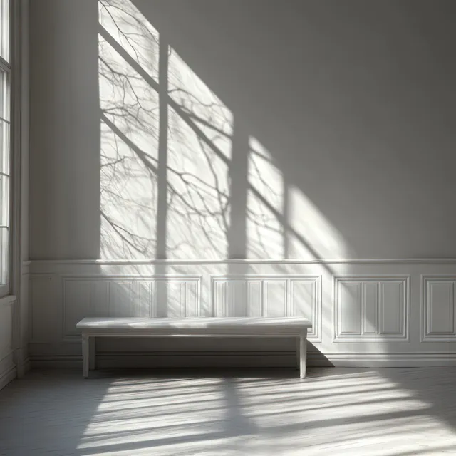 Empty minimalist white room with bench as tree-branch shadows sweep across paneled wall