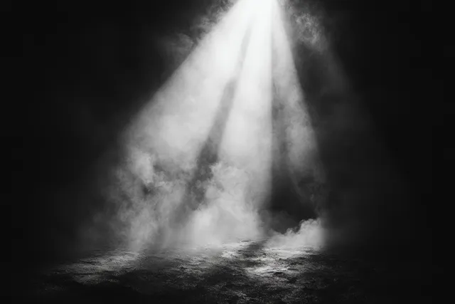 Bright spotlight beam cutting through smoky fog with deep shadows and dust particles