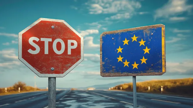 Weathered STOP sign and worn EU flag sign beside quiet rural road under blue clouds