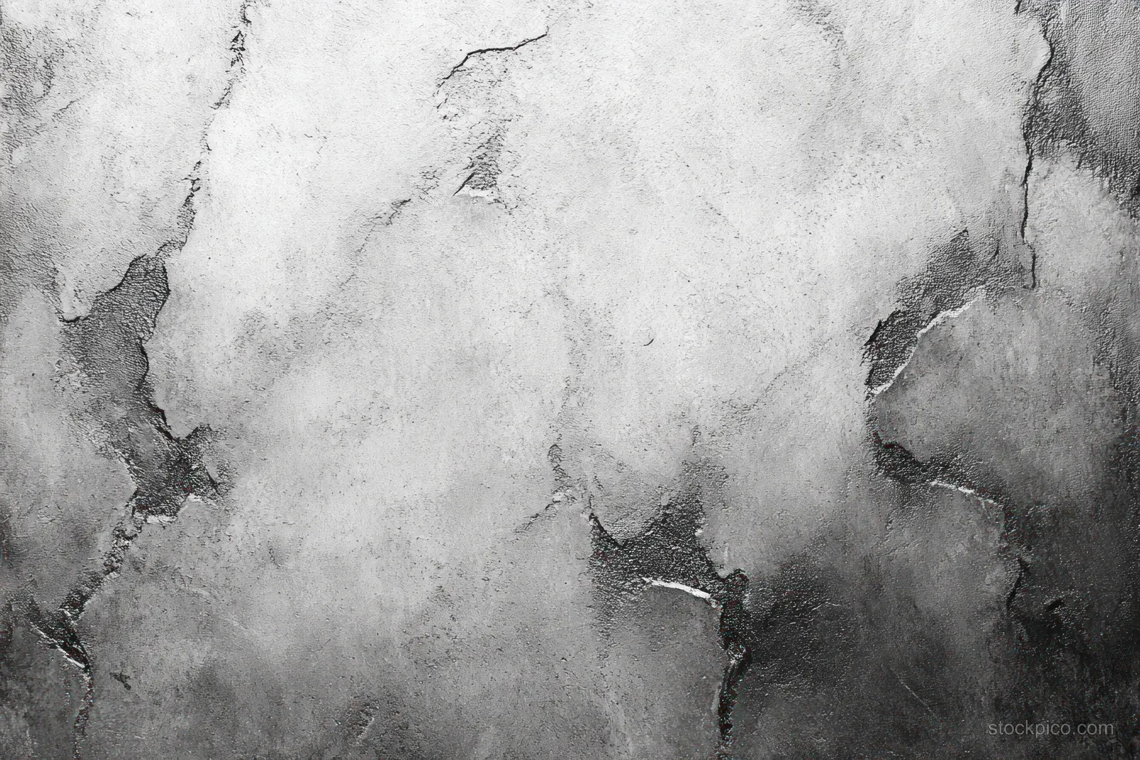 Close-up view of a cracked gray concrete wall with peeling plaster and rough uneven weathered texture.