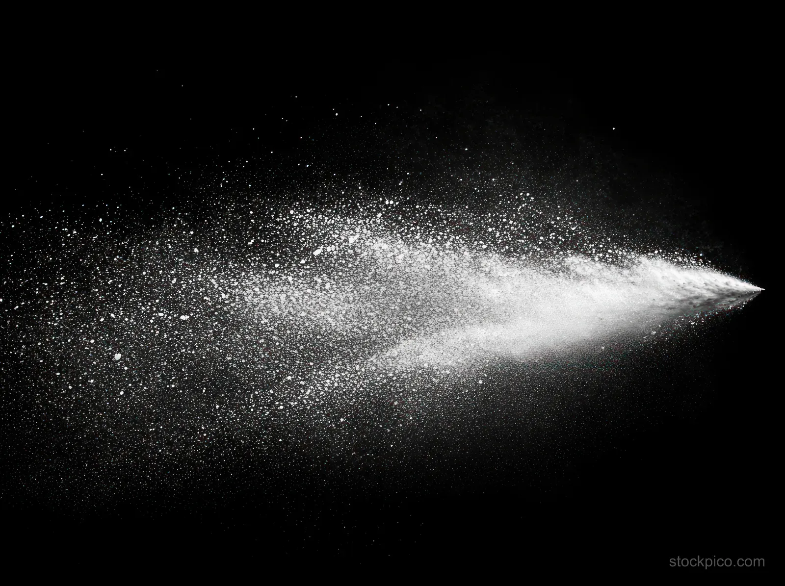 Monochrome water spray mist creates a textured plume of droplets across a dark background.