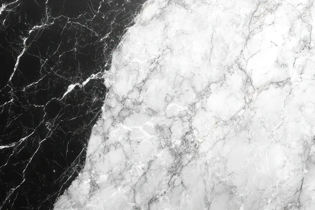 Close-up of black and white marble texture with sweeping veins forming a high-contrast split pattern.