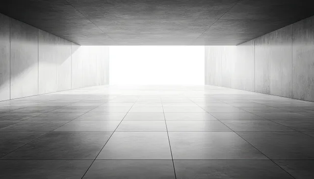 Empty concrete tunnel interior with smooth tiled floor and a bright exit casting sharp light and shadow.
