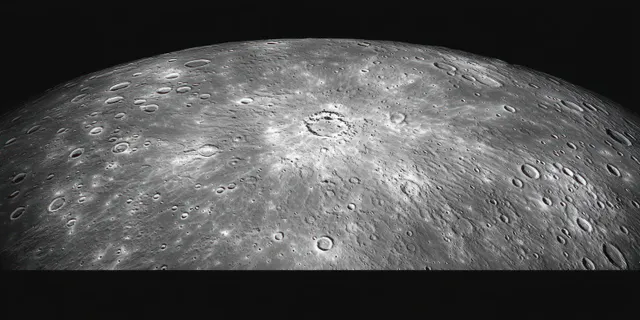 Close-up of a cratered lunar surface lit from the side against black space.