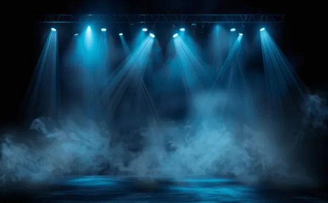 Blue stage spotlights beam through smoke over empty concert floor