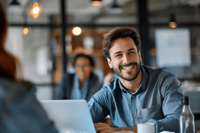 Diverse coworkers discussing project strategy at a modern office desk