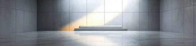 Gray interior space with polished marble floor and daylight creating long soft shadows across the walls.