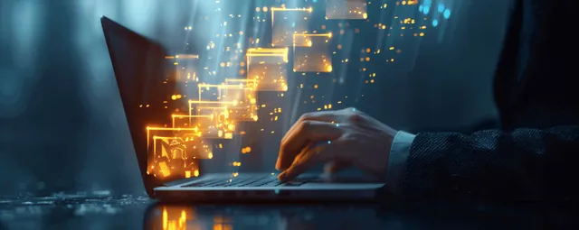 A hand typing on a laptop with glowing document and data icons floating over a dark office desk.