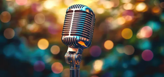 Vintage microphone on a stage with colorful warm bokeh lights in the background.