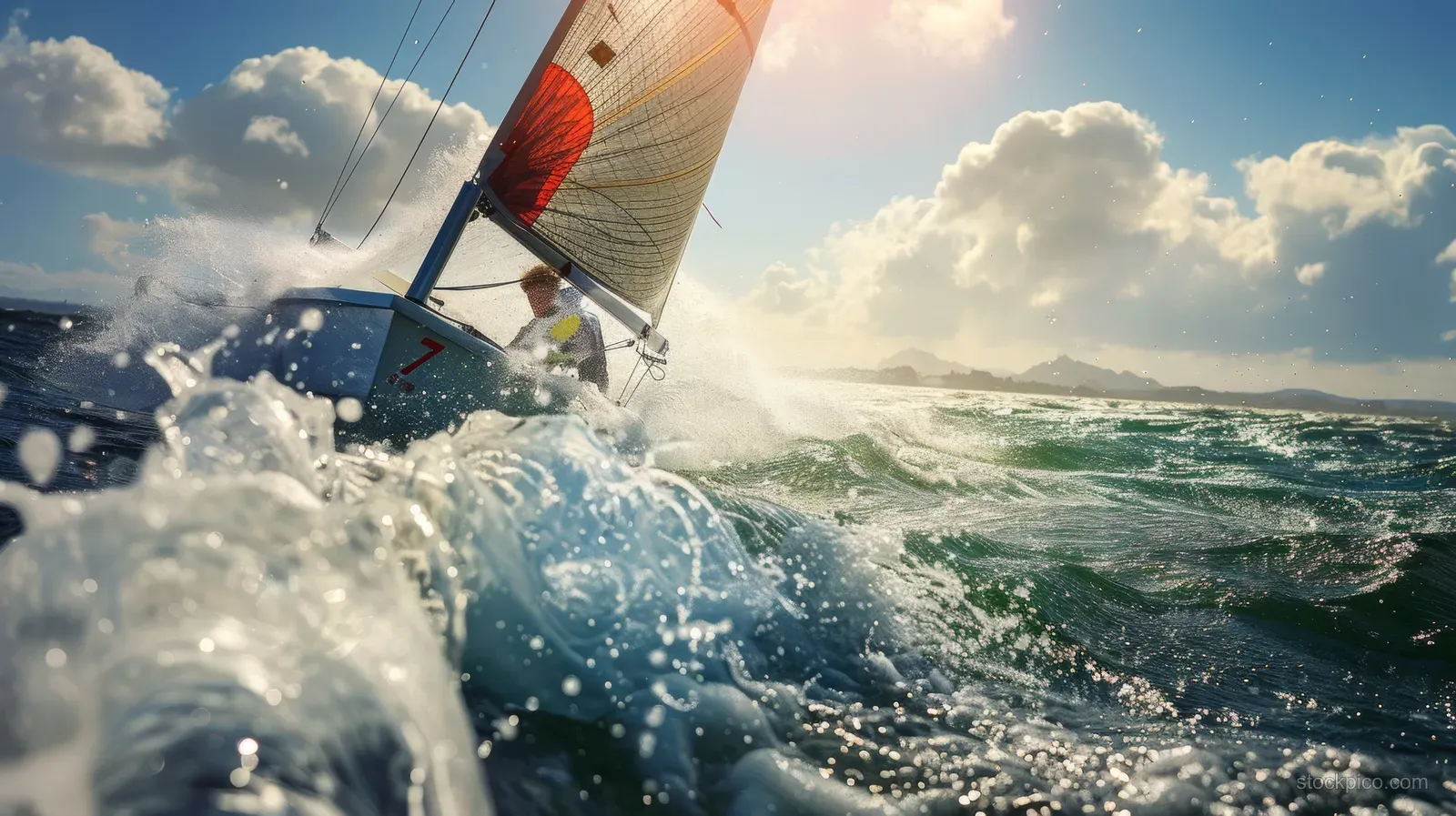 British sailor races in Finn class, navigating choppy waves and strong winds beneath dramatic coastal skies.