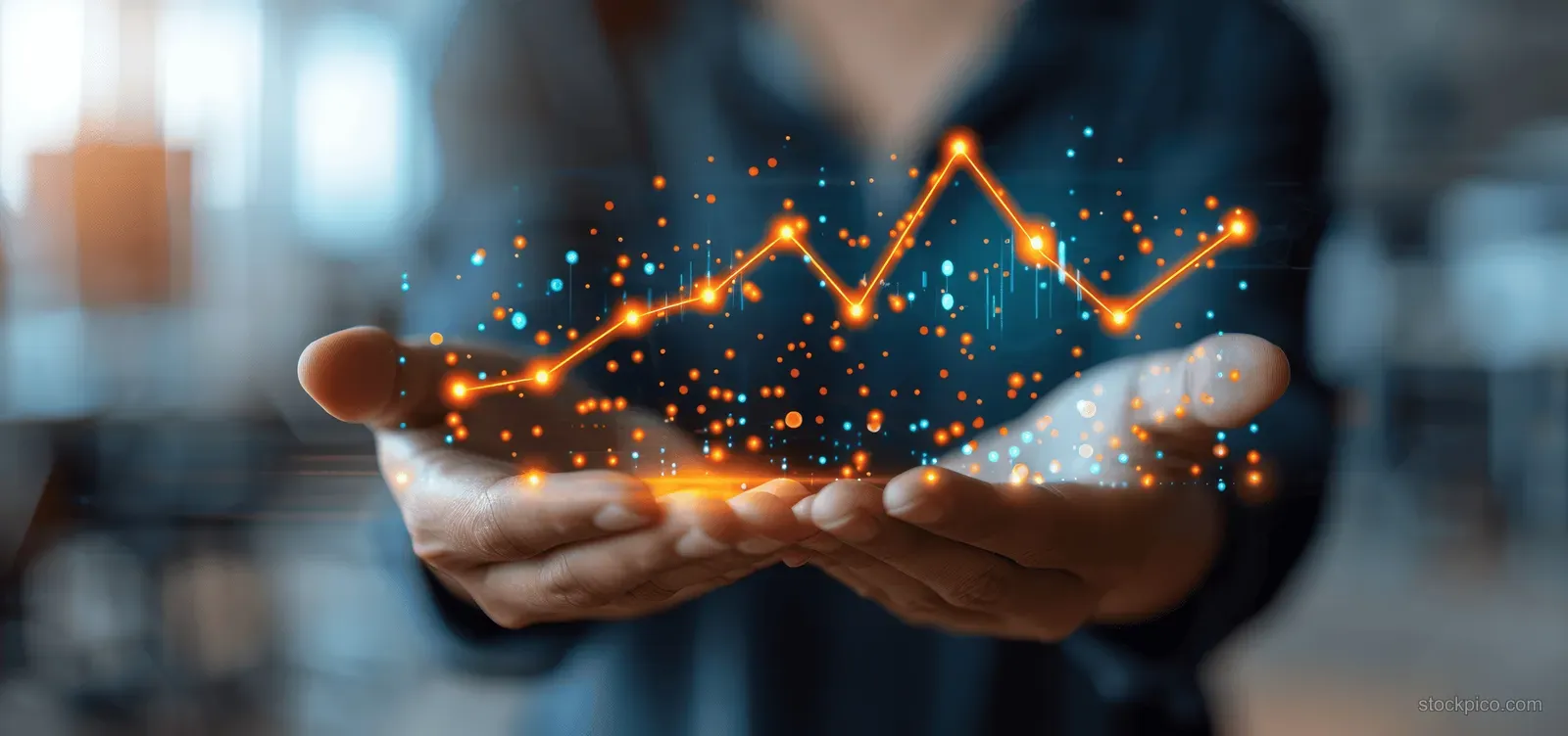 A business analyst’s hands display a glowing line chart of growth over a blurred office background.