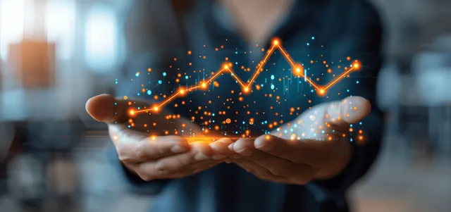 Business analyst holding hands with glowing growth chart over blurred office background
