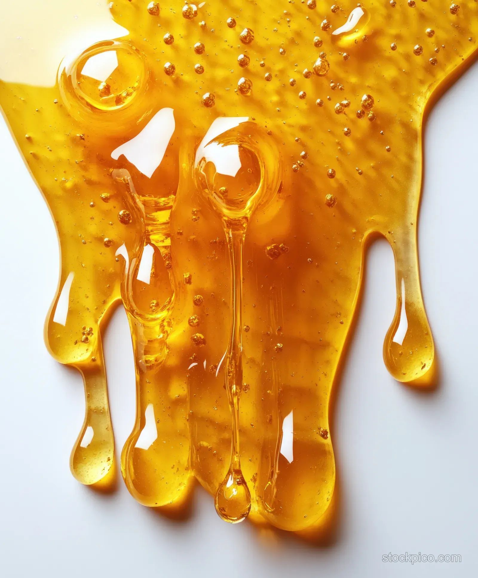 Golden fish oil capsules drip and pool on a white background.
