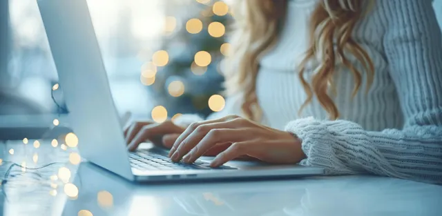 Businesswoman typing on laptop with digital tablet beside her in softly lit office