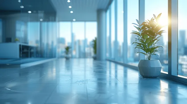 Minimalist office corridor with glass windows and a potted plant in the foreground under daylight.