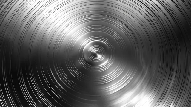 Brushed metal circular texture with polished spiral reflections on dark steel background