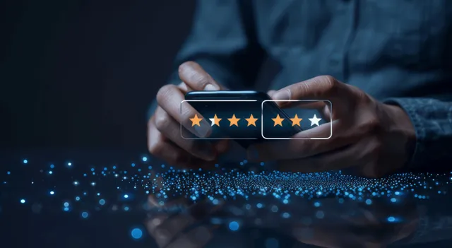 Businessperson holding smartphone showing five-star rating icons on dark interface glow