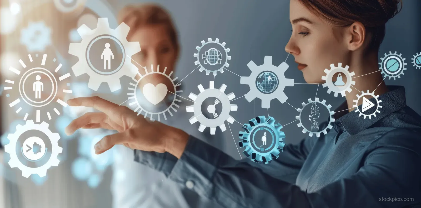 Two coworkers gesture at a digital display filled with engagement, feedback, and recognition icons.