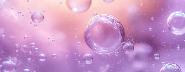 Transparent bubbles suspended in glowing pink and purple liquid with a soft gradient background.