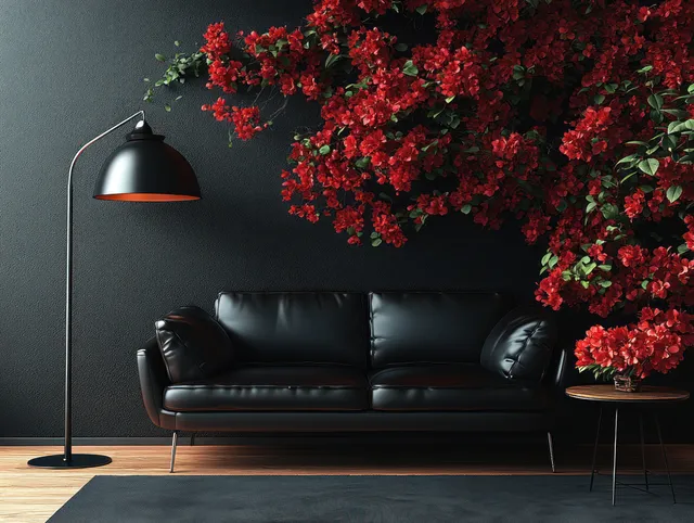 A black leather sofa in a minimalist living room with a standing lamp and red flowers on the wall.