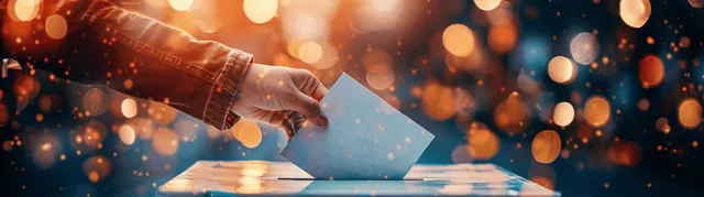 Hand Casting Ballot Into Transparent Box at Election Station