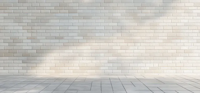 Empty room interior with white brick wall and gray tiled floor under soft daylight