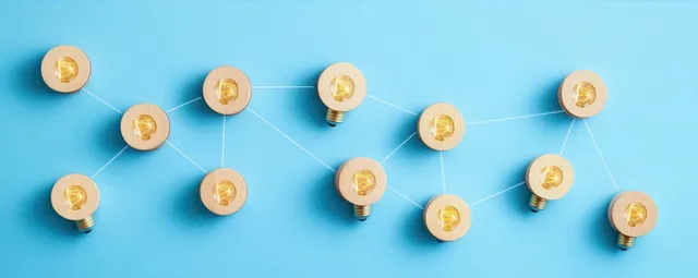 Glowing light bulbs connected by white lines on a blue background forming an idea network.