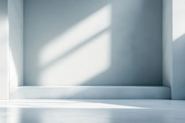Minimalist white interior corner with window light beams casting soft shadows on walls and floor.