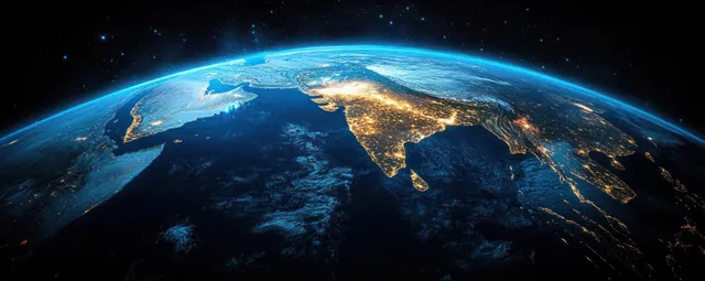 Earth from orbit at dusk showing India, Tibet, and the Himalayas glow under thin cloud layers