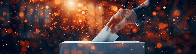 Hand dropping a ballot into an illuminated box amid glowing blockchain-like particles