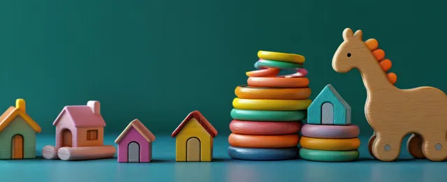 Colorful wooden educational toy blocks stacked beside small houses and giraffe figurine