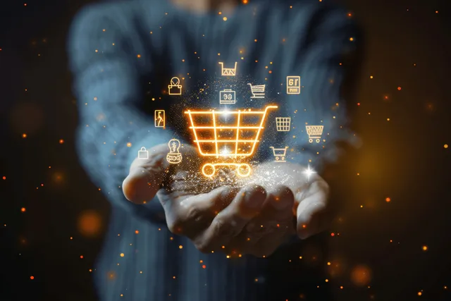 Hands holding a glowing shopping cart icon amid digital payment symbols