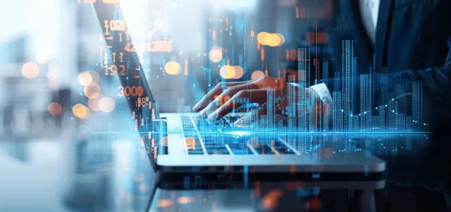A business analyst reviews data on a laptop and tablet with glowing digital growth graphs overlaying the scene.
