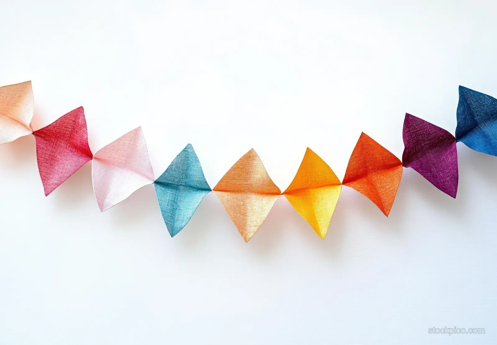 Triangular translucent fabric pennants form a colorful garland strung across a white background.