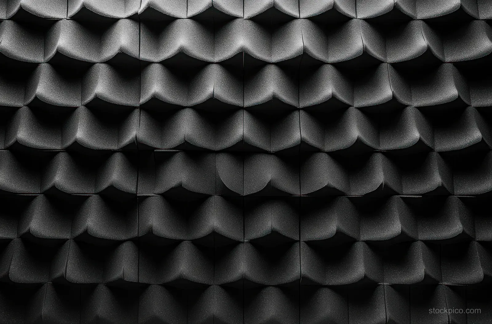 Matte black surface with repeating 3D dome pattern and soft shadows creating depth.