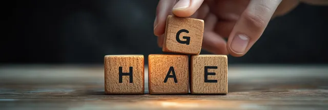 Hand arranging letter wooden blocks spelling HAiE on a rustic table