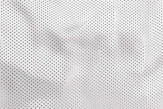 White perforated one-way vision window film closeup showing small repeating holes pattern texture
